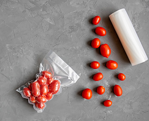 Vacuum packaging of fresh tomatoes. Flat lay. Copy space.
